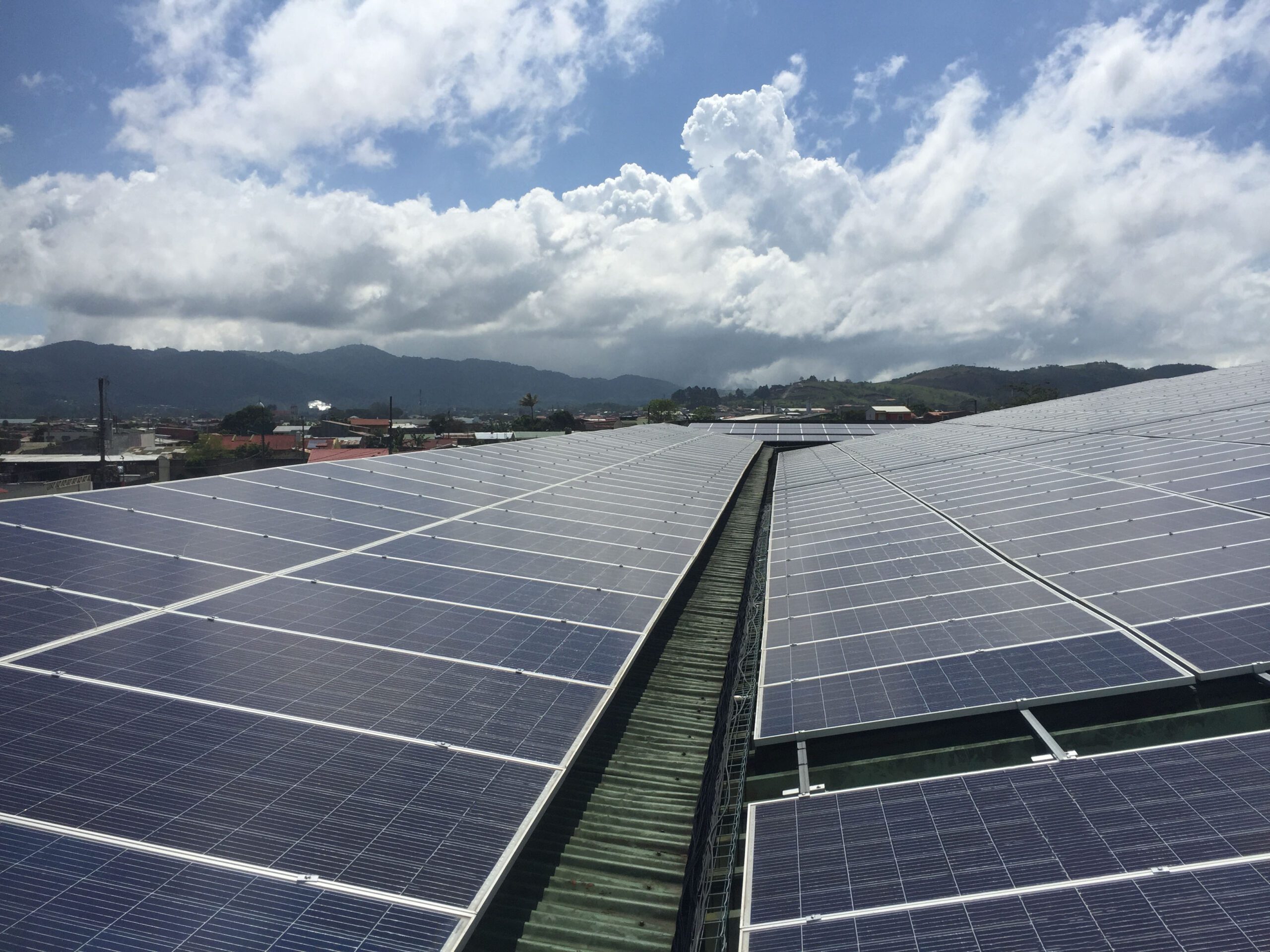 Sistema fotovoltaico sobre un techo en Costa Rica, bajo nubes.